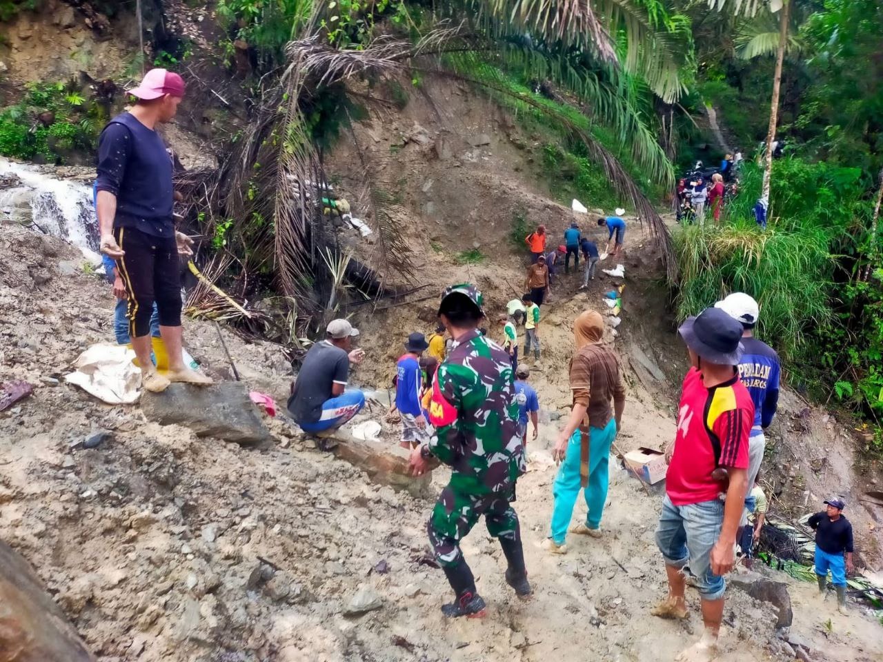 Babinsa Koramil 1418-05/Kalumpang Bantu Warga Perbaiki Jalan Perkebunan